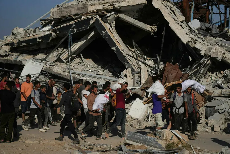 Palästinenser tragen humanitäre Hilfsgüter, die von der Gaza Humanitarian Foundation verteilt werden, einer von den USA unterstützten Organisation in Khan Younis im südlichen Gazastreifen, Donnerstag, 26. Juni 2025. (AP Photo/Abdel Kareem Hana) Credit: Abdel Kareem Hana/אי־פי